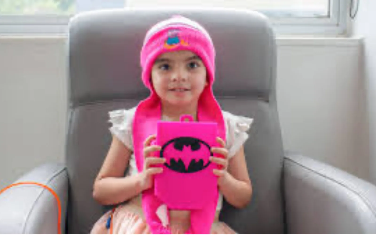 Niña con una caja rosa de superheroína